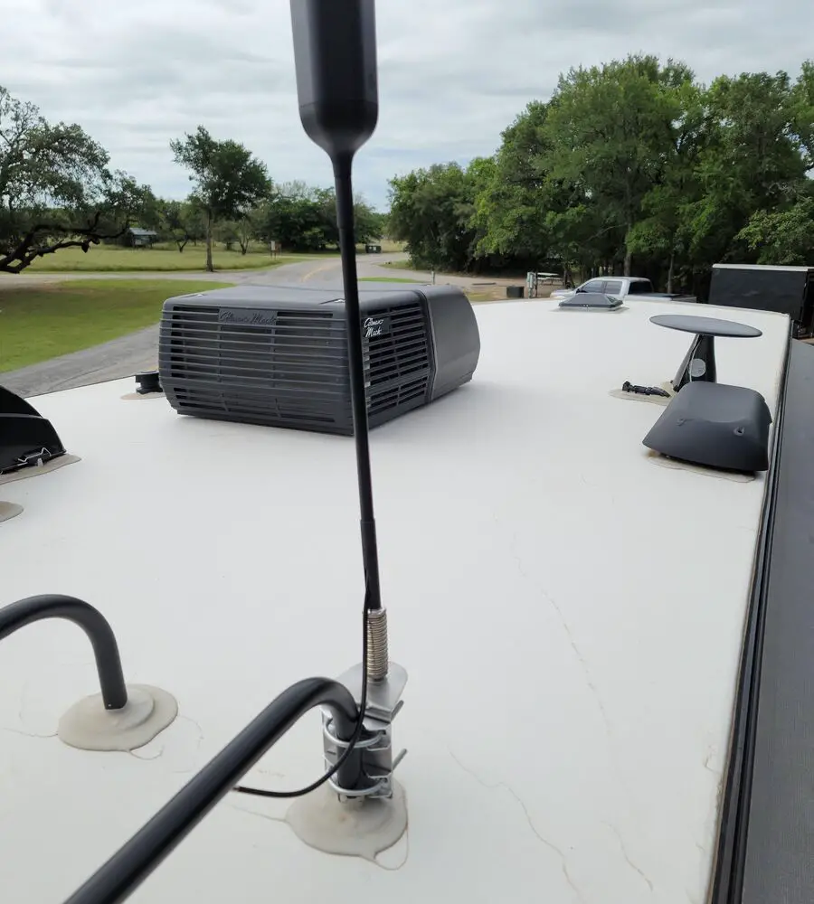 WeBoost RV WiFi booster mounted on top of an RV in a camp in a camp ground.jpg
